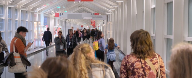 Menschen laufen einen hellen Gang entlang.